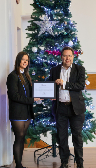 Craig Hoy MSP presents Eva Knox with framed parliamentary motion.